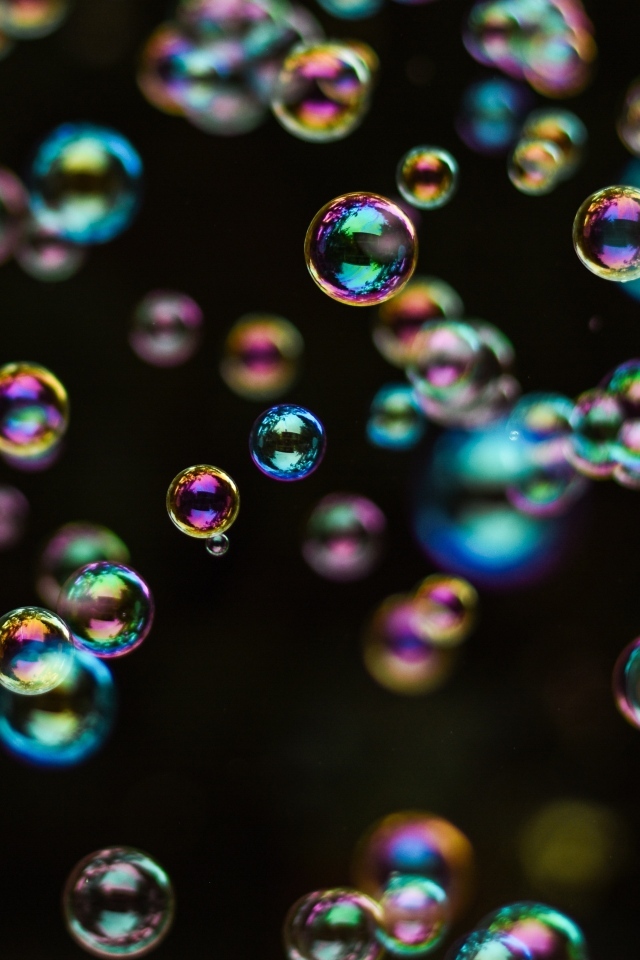 Разноцветные мыльные пузыри на черном фоне