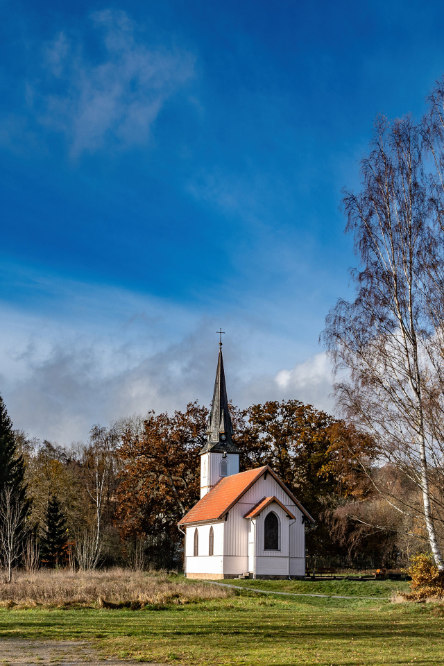 Старая часовня в парке под красивым голубым небом