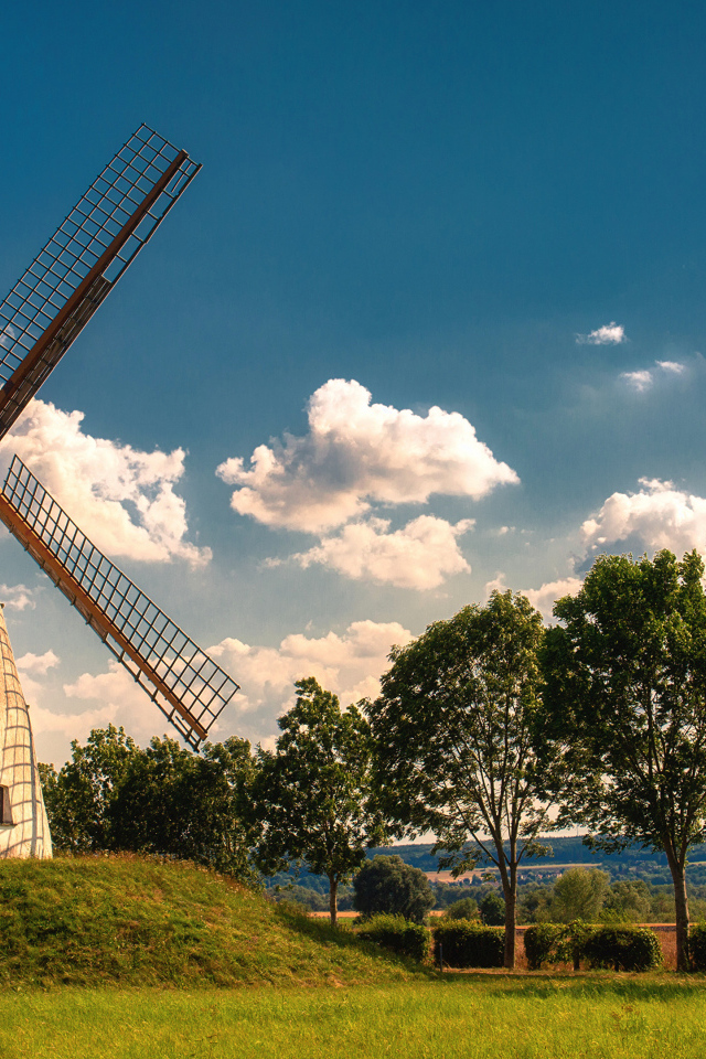 Старая мельница с зелеными деревьями