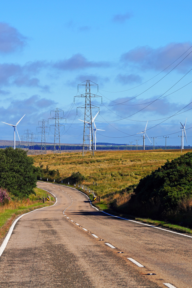 Ветрогенераторы в поле у дороги под голубым небом