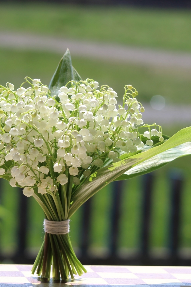 Красивый букет белых ландышей на столе в вазе