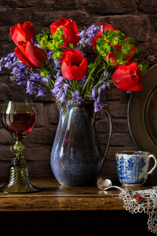 Букет цветов на столе со свечой и вином