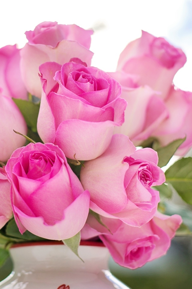 Букет розовых роз в вазе на столе 