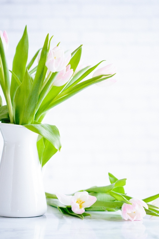 Букет розовых тюльпанов в белой вазе на столе