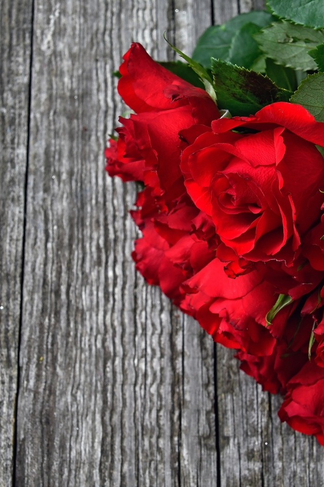 Букет красных роз на деревянном столе