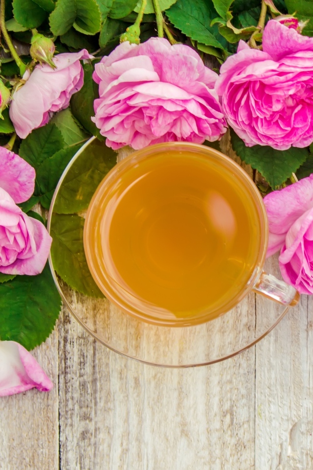 Букет роз с чашкой чая на столе