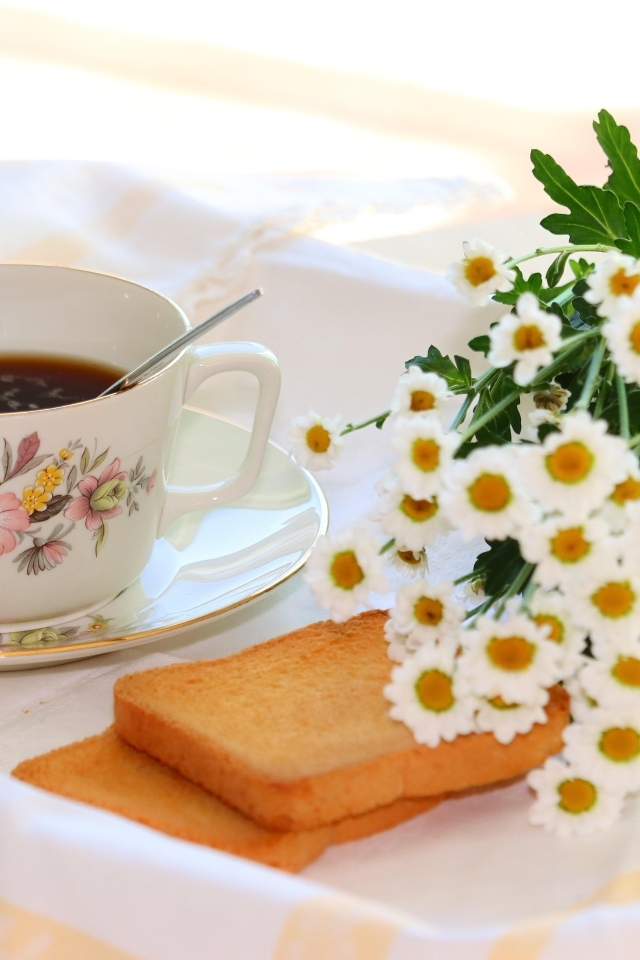 Букет белых ромашек с чашкой чая  и хлебом