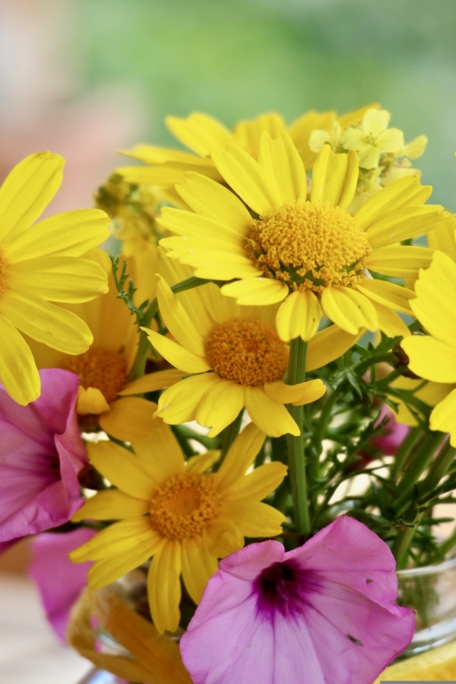 Букет желтых и розовых цветов в вазе на столе