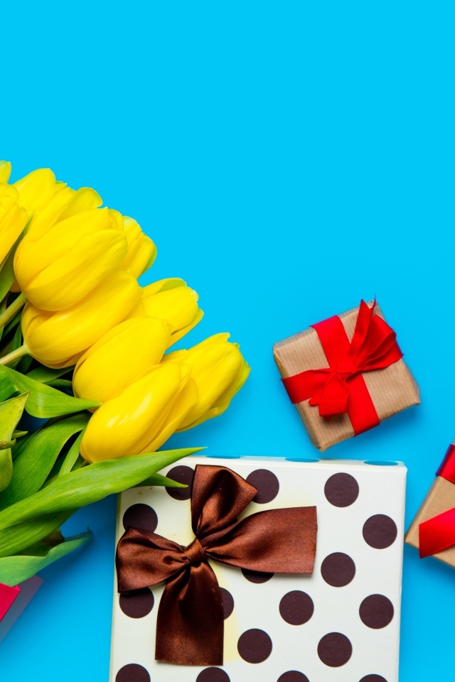 Букет желтых тюльпанов с подарками на голубом фоне