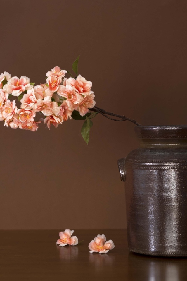 Ветка с розовыми цветами в вазе на столе