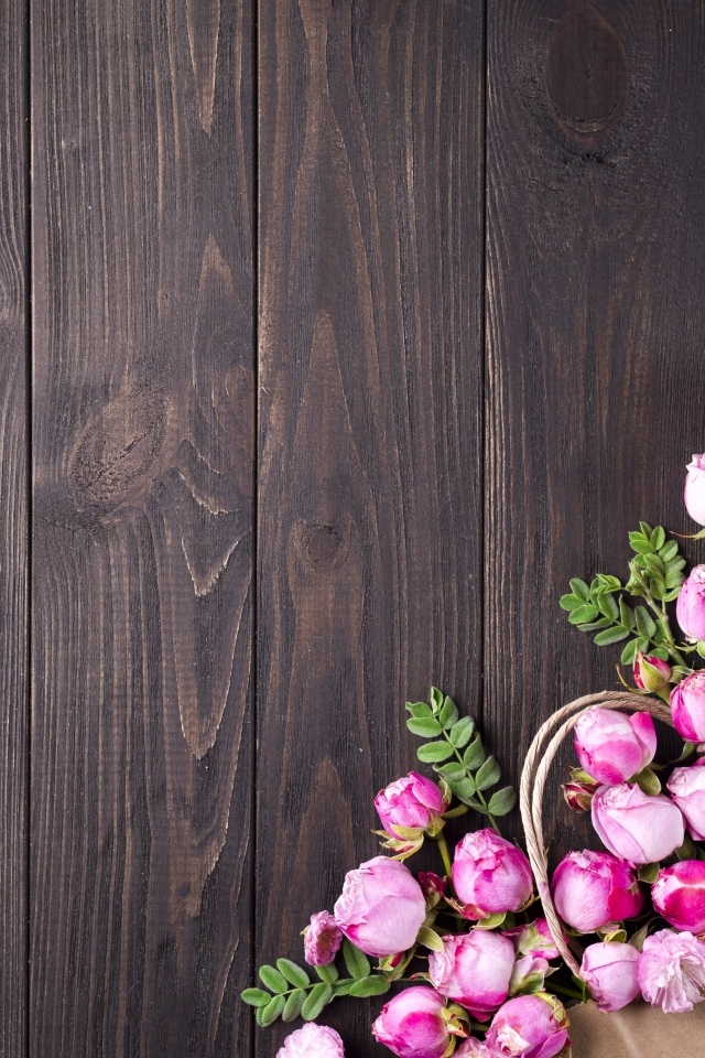 Бутоны розовой розы на деревянном столе