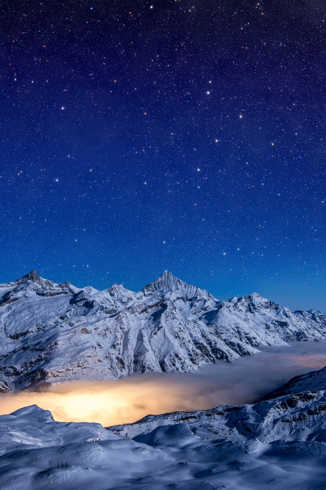 Красивое ночное небо над покрытыми снегом горами