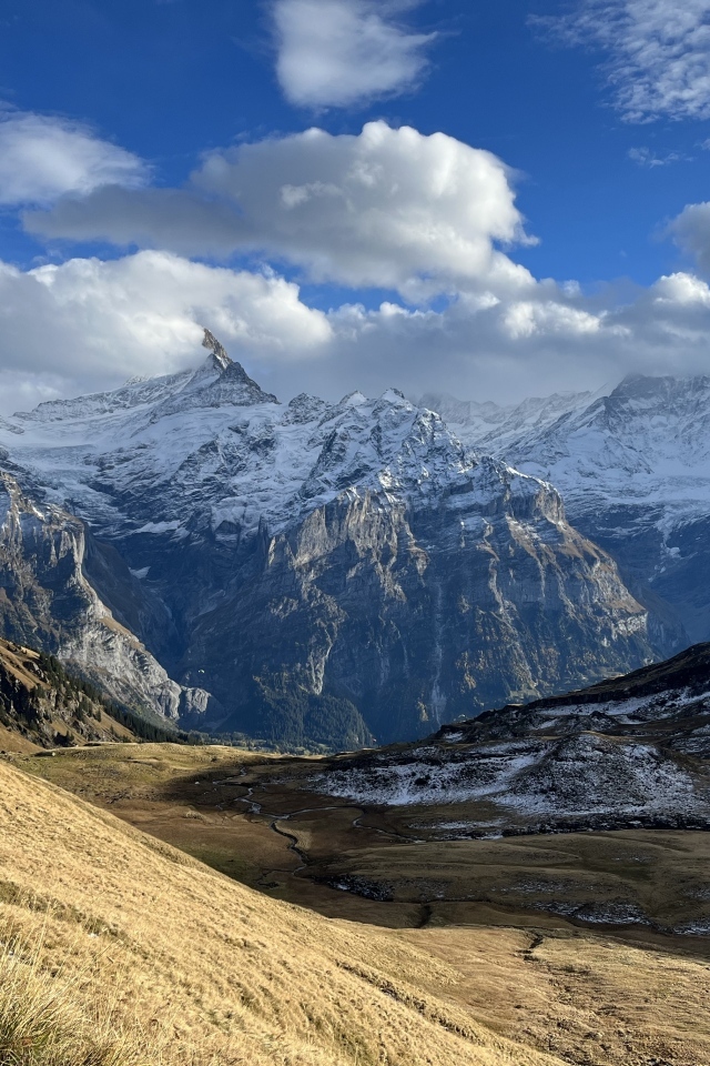 Высокие покрытые снегом горы в белых облаках