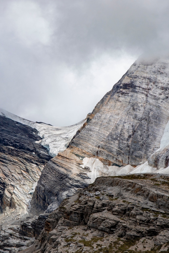 Высокие каменные горы в белых облаках