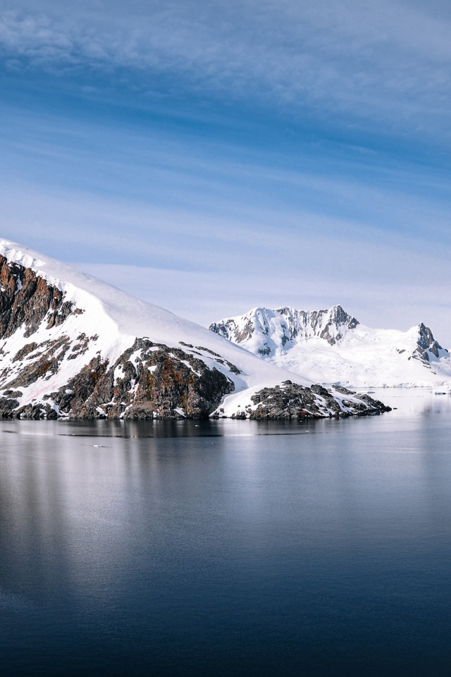 Скала в море покрыта снегом