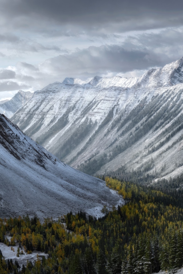 Покрытые снегом горы под грозовым небом