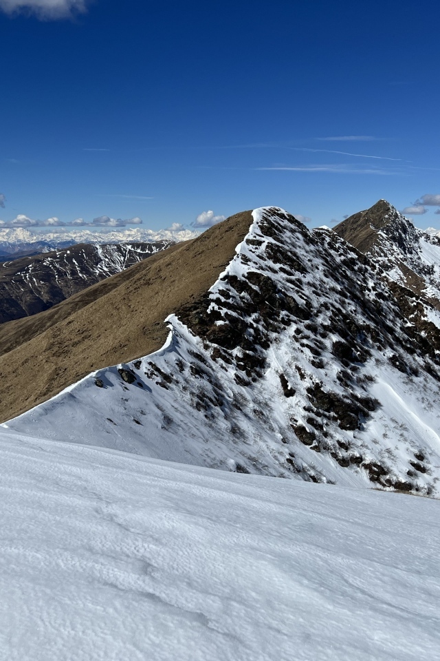 Вид на заснеженную гору под голубым небом