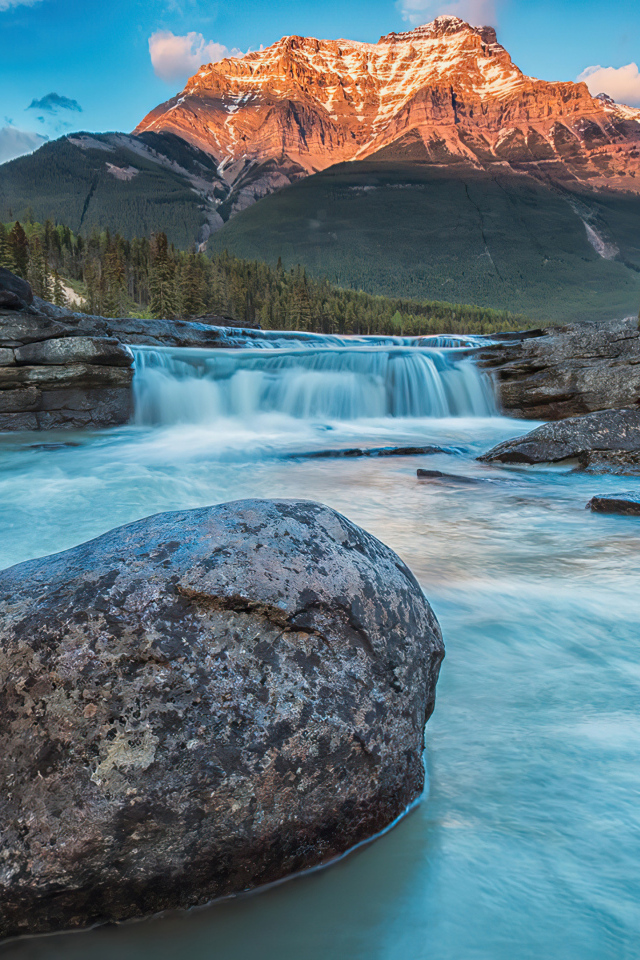 Большой камень лежит в реке у горы