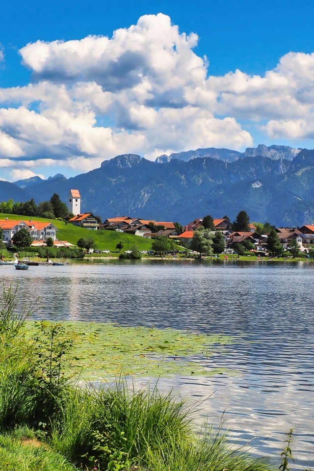 Красивый вид на озеро и горы под голубым небом с белыми облаками