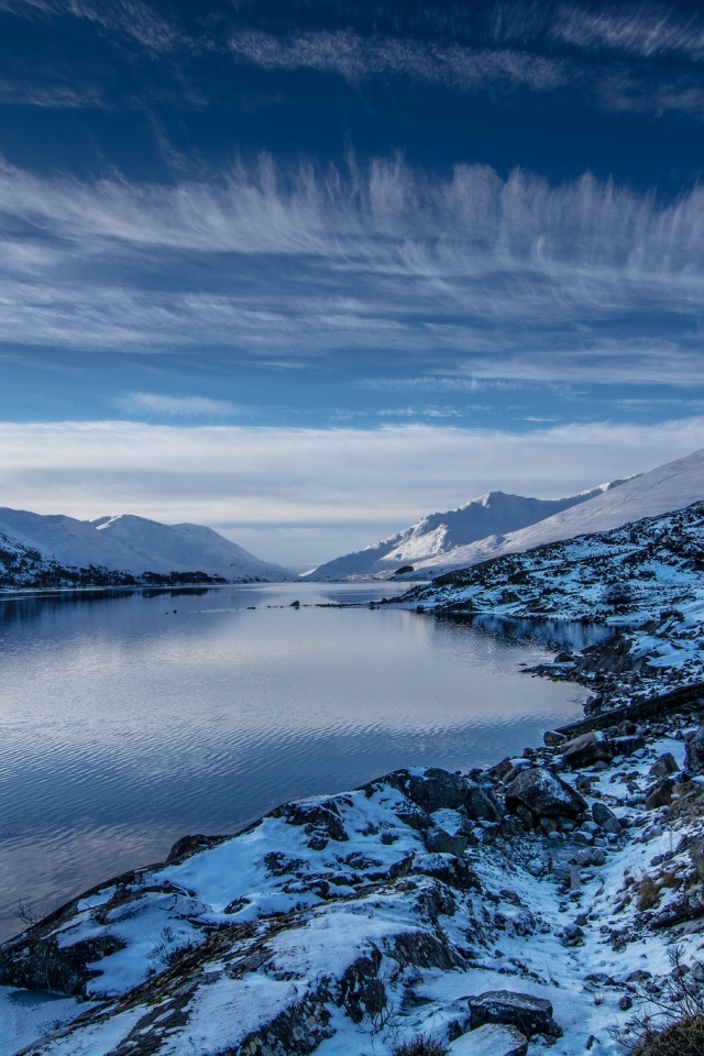 Озеро с покрытыми снегом горами под красивым небом