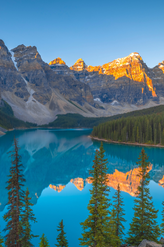 Солнце над вершинами гор у голубого озера