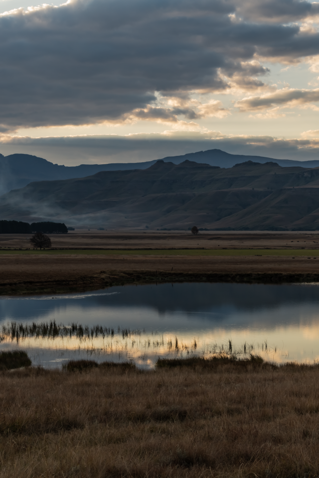 Грозовые облака отражаются в воде озера в горах 