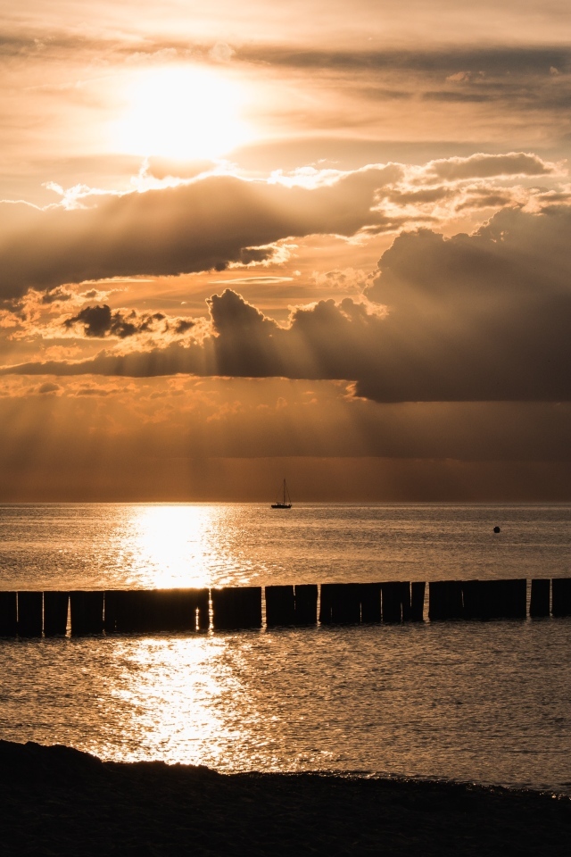 Яркое солнце за облаками над морем