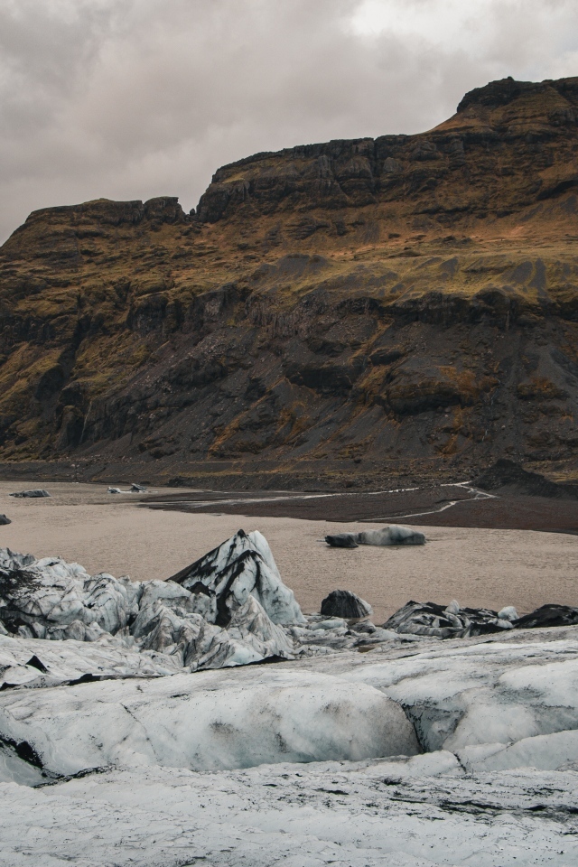Холодный грязный снег на берегу моря у гор 