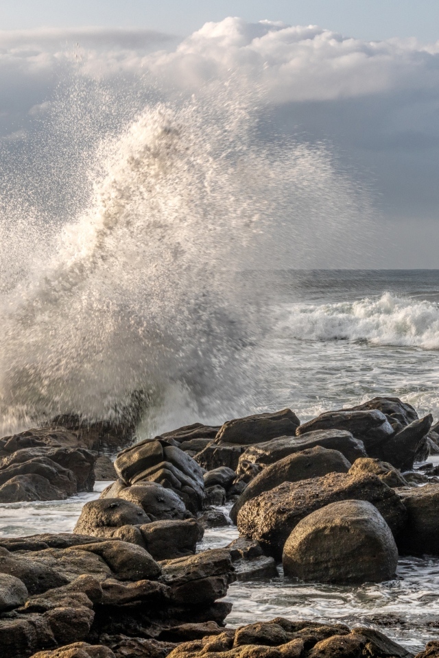 Морские волны бьются о камни на берегу