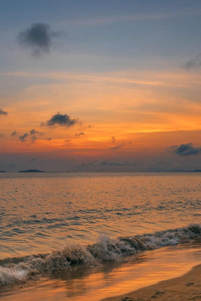 Морские волны омывают берег на закате