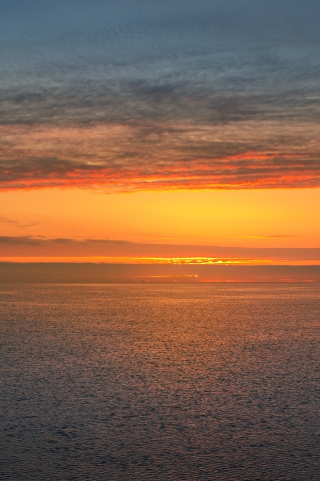 Яркий оранжевый закат на морском горизонте