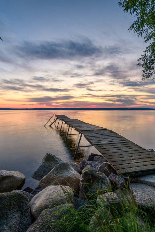 Старый деревянный пирс у озера на закате