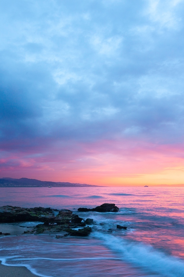 Розовый закат в пасмурном небе над морем