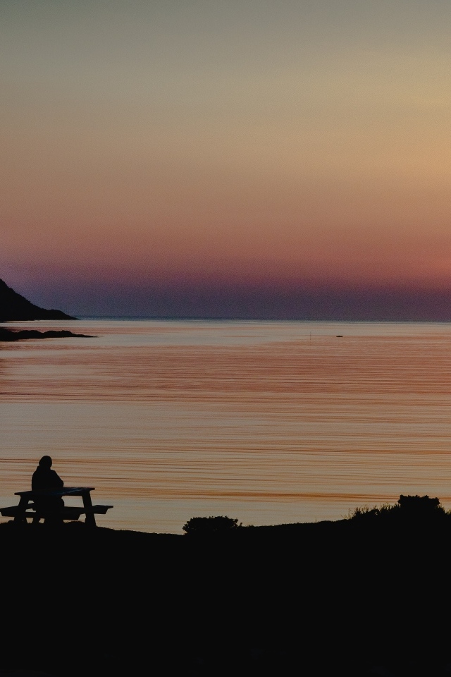 Солнце скрывается за горой в заливе