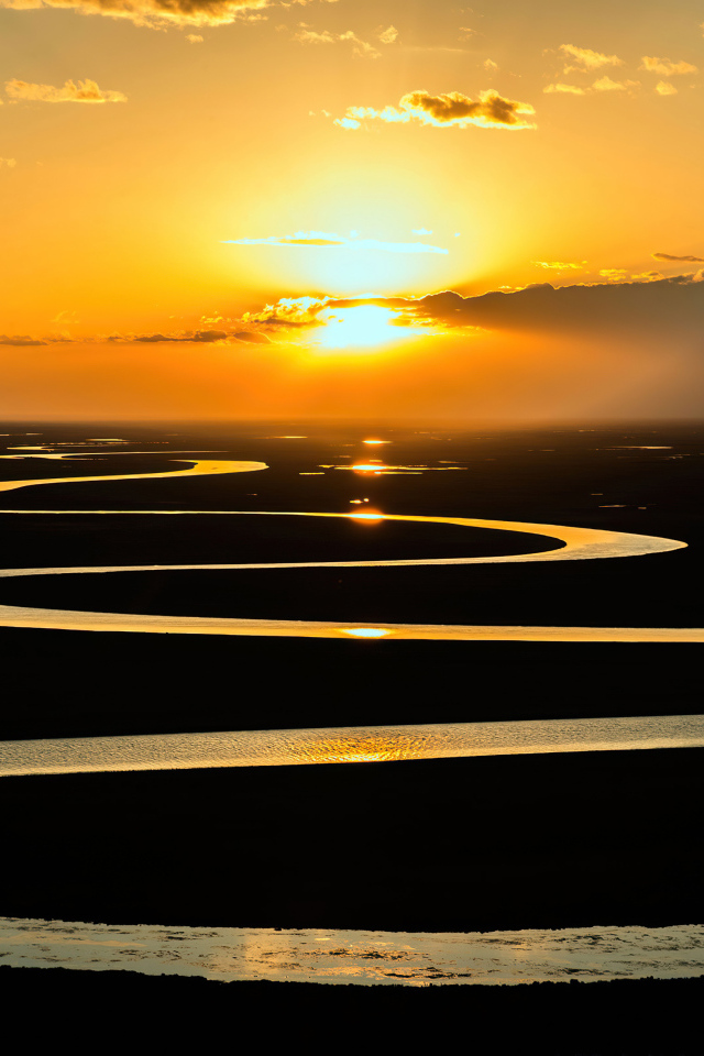 Извилистая река в лучах солнца на закате