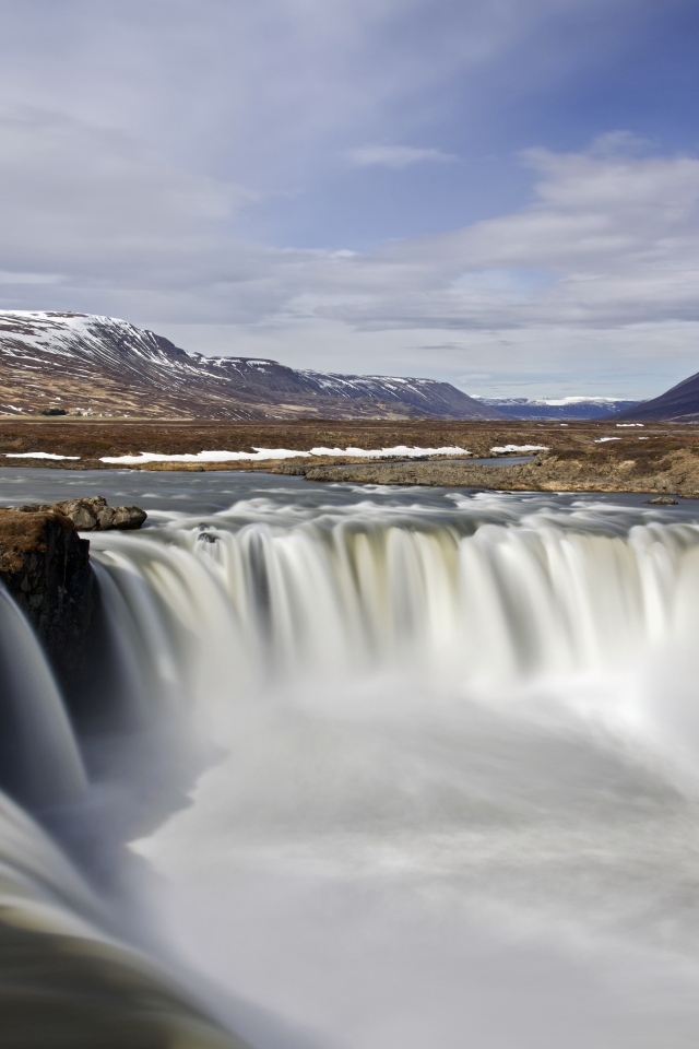 Водопад стекает вниз на фоне гор