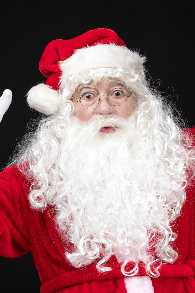 Удивленный Санта Клаус с колокольчиком в руках