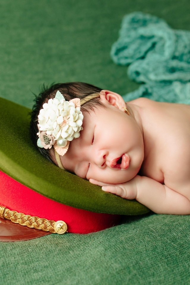 Маленький ребенок спит на военной фуражке