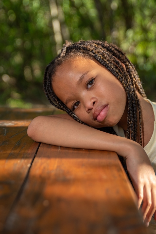 Красивая темнокожая девочка с косичками на голове 
