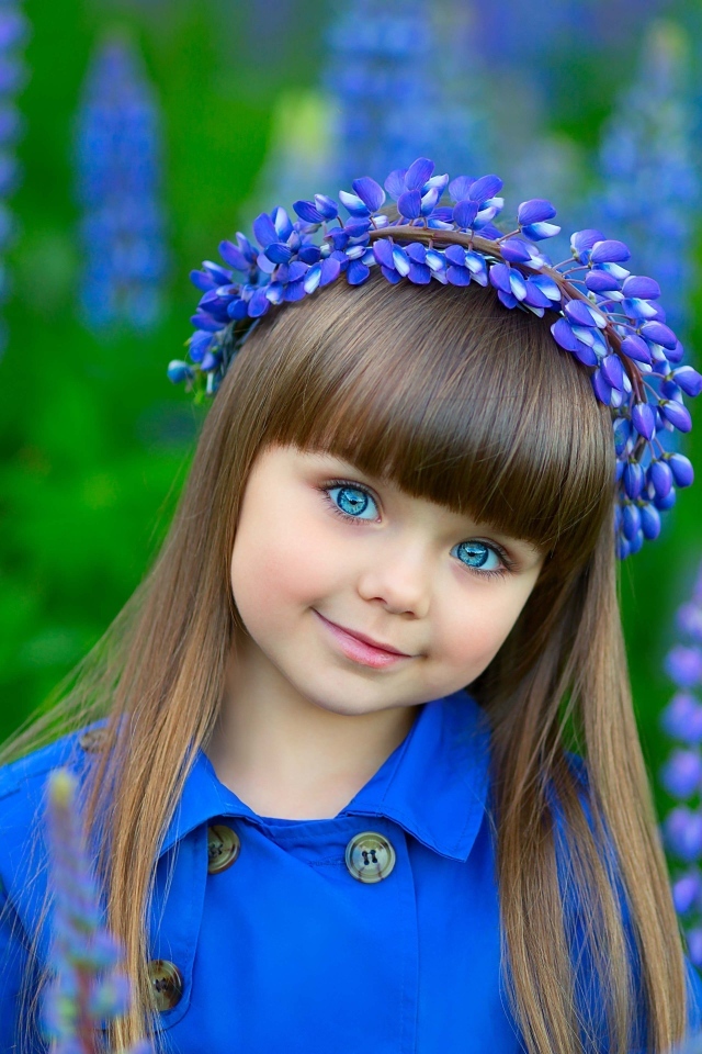 Красивая маленькая девочка в цветах люпина