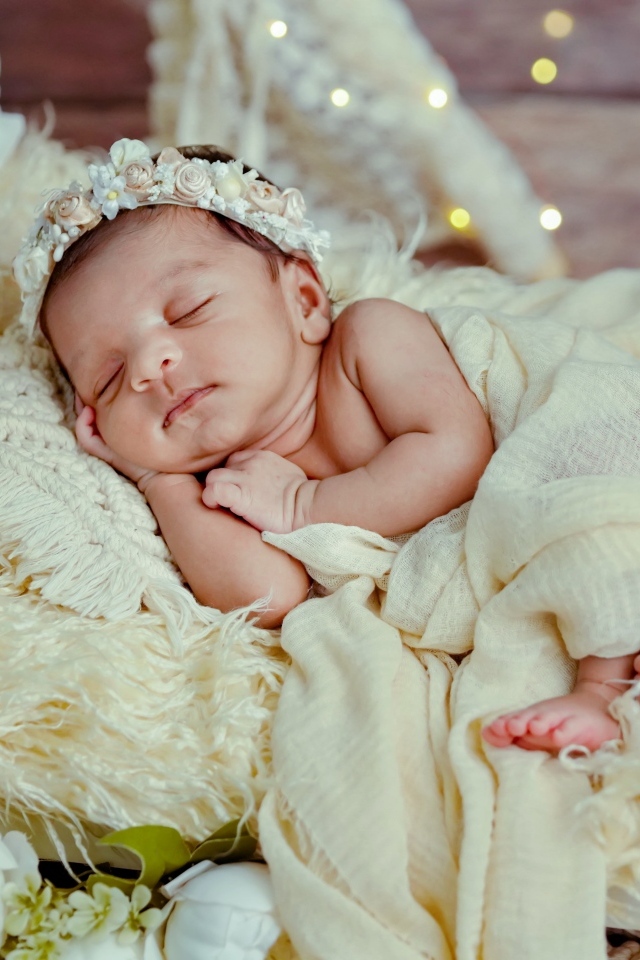 Красивая новорожденная девушка с венком на голове 