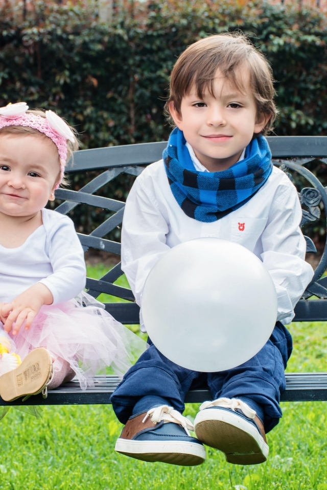 Мальчик и девочка сидят на лавке в парке