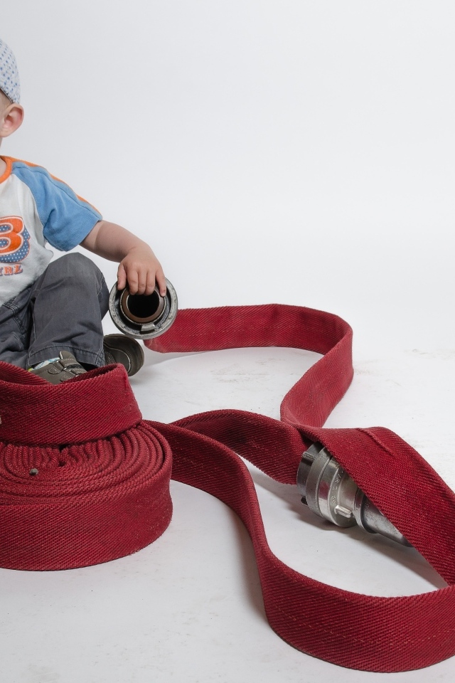 Мальчик с красным пожарным шлангом