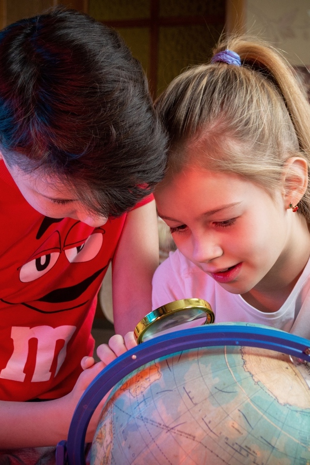 Дети школьники изучают глобус