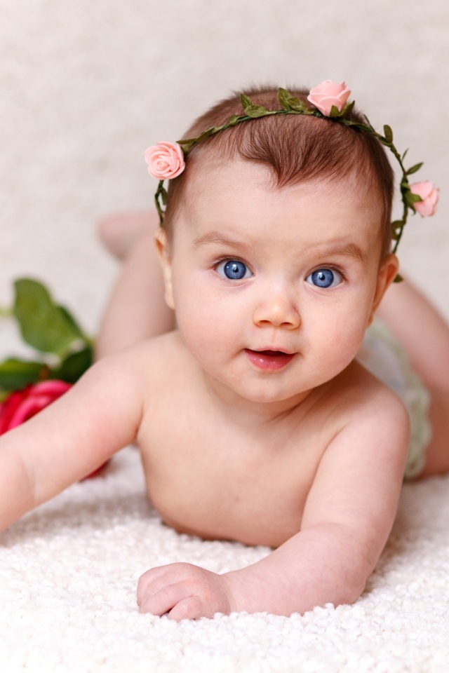 Милая голубоглазая малышка с цветами роз