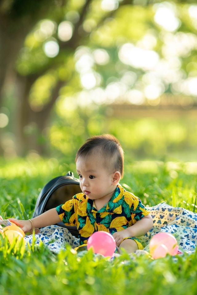 Милый маленький ребенок сидит на траве