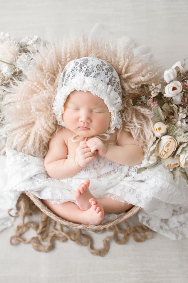 Милый спящий ребенок в белой шапке 