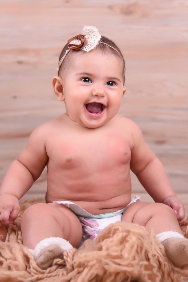 Милый улыбающийся ребенок на фоне деревянной стены