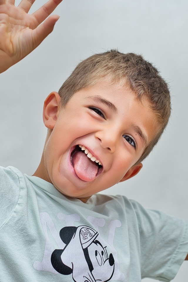 Смешной мальчик высунул язык