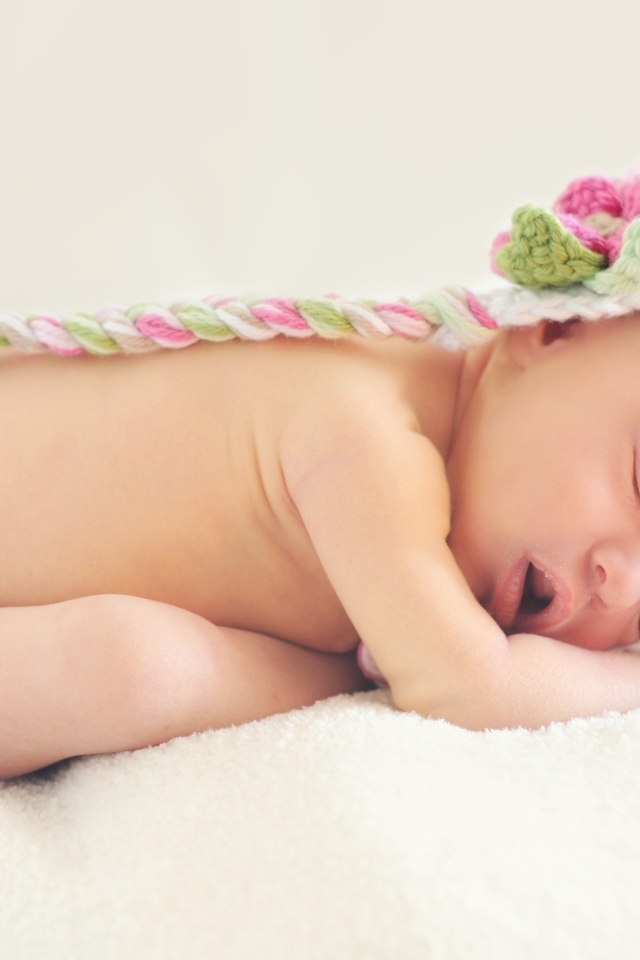 Нежный спящий ребенок в вязаной шапке 